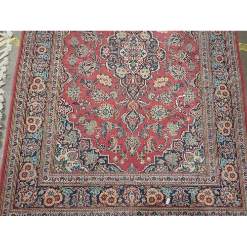 524 - A Persian red ground Rug with floral design around central blue lozenge within tramline border 4ft 5... 