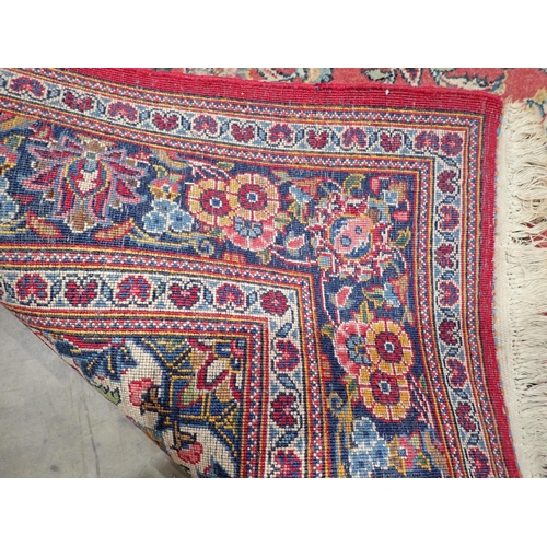 524 - A Persian red ground Rug with floral design around central blue lozenge within tramline border 4ft 5... 