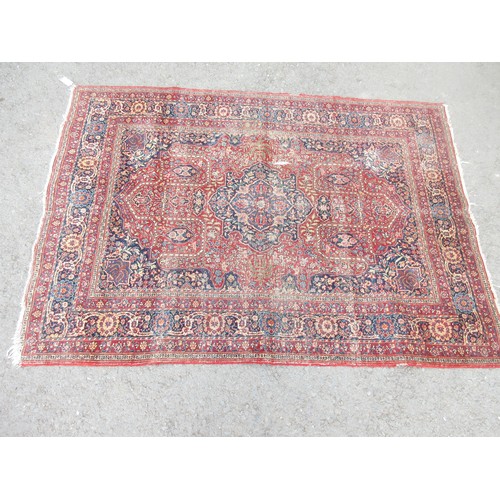 103 - An early 20th Century bordered Persian Rug with central floral medallion on a red ground, 6ft 6in x ... 