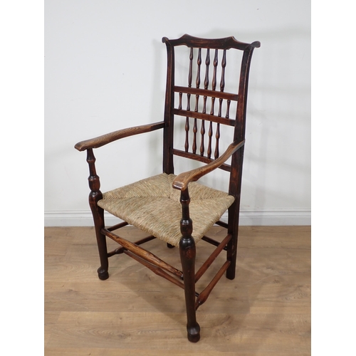 108 - A 19th Century ash eared spindle back Elbow Chair with rush seat