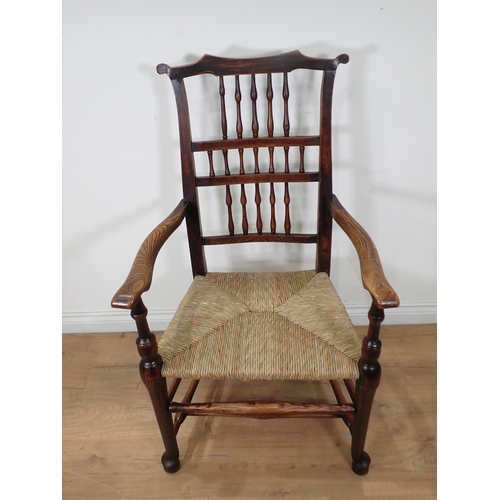 108 - A 19th Century ash eared spindle back Elbow Chair with rush seat