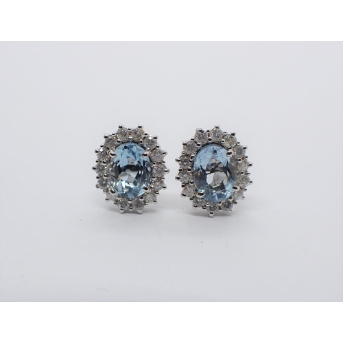 162 - A pair of Aquamarine and Diamond Cluster Earrings each claw-set oval-cut aquamarine, total weight 1.... 