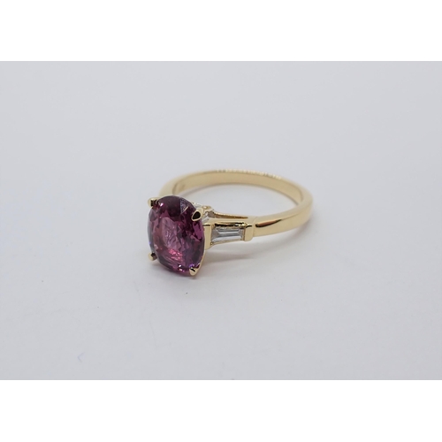 174 - A Pink Sapphire and Diamond three stone Ring claw-set oval-cut sapphire between two tapered baguette... 