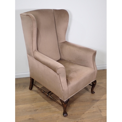 30 - A beige upholstered wingback Armchair on cabriole front supports