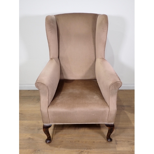 30 - A beige upholstered wingback Armchair on cabriole front supports