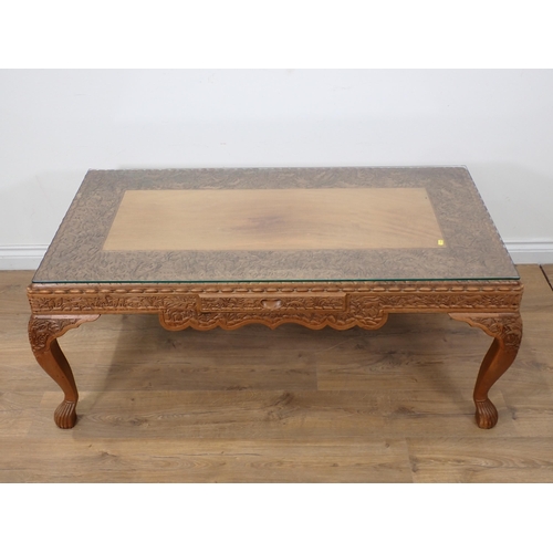 63 - An Eastern carved hardwood Coffee Table with glass top 4ft 1in W x 1ft 8in H