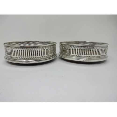 11 - A pair of modern silver pierced circular Coasters with turned wooden bases, London 1983