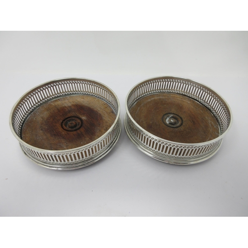 11 - A pair of modern silver pierced circular Coasters with turned wooden bases, London 1983