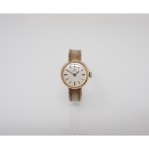 132 - A lady's 1960's Omega Wristwatch the cream dial with hourly baton markers on integral woven link bra... 