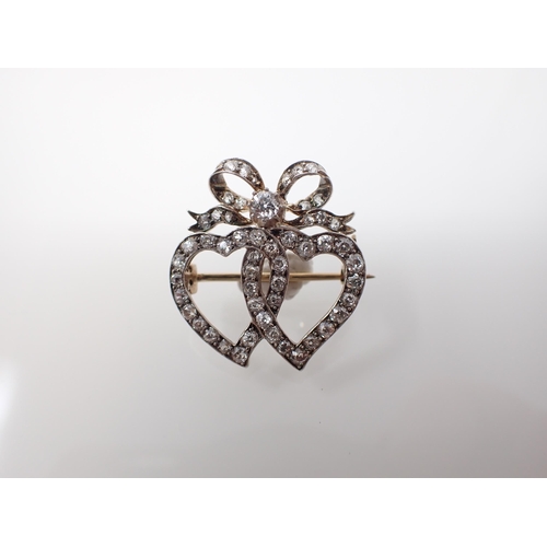 142 - A 19th Century Diamond Brooch the interlocking hearts pavé-set old cut stones throughout in silver b... 