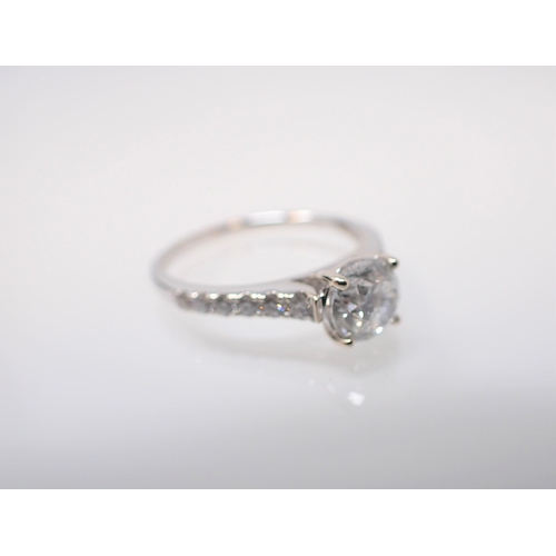 146 - A Diamond Ring claw-set principle brilliant-cut stone between graduated stones pavé-set to shoulders... 