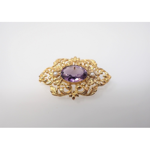 151 - An Amethyst and Seed Pearl Brooch set oval-cut amethyst between two seed pearls within intricate ope... 