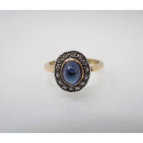 166 - A 1960's Sapphire and Diamond Cluster Ring rubover-set oval cabochon sapphire within a frame of pavé... 