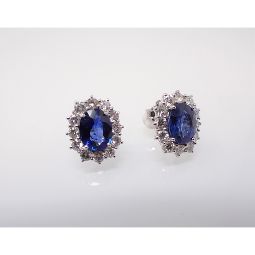 168 - A pair of Sapphire and Diamond Cluster Earrings each claw-set oval-cut sapphire, approx 2cts, within... 