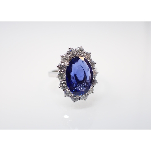 174 - A Sapphire and Diamond Cluster Ring claw-set oval-cut sapphire, 4.02cts, within a frame of fourteen ... 