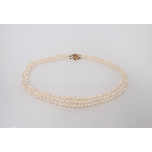 195 - A three strand graduated Cultured Pearl Necklace on 9ct gold clasp claw-set oval-cut citrine within ... 