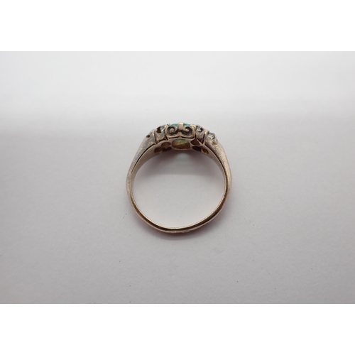 197 - An Emerald and Diamond Ring pavé-set step-cut emerald between trios of rose-cut diamonds, ring size ... 