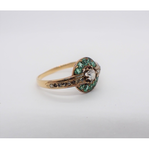 209 - A Cluster Ring claw-set white stone within step-cut emeralds and rose-cut diamonds in bands of white... 