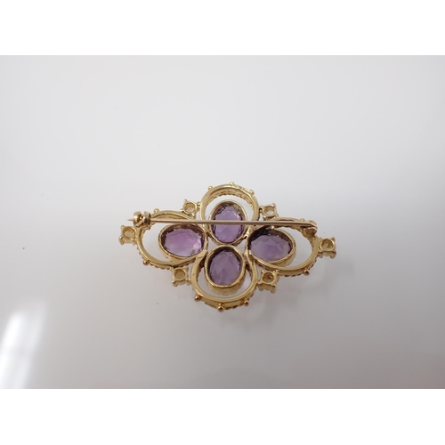 216 - An Amethyst and Cultured Pearl quatrefoil Brooch set four oval-cut amethysts within seed pearls in 9... 