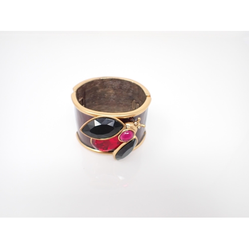 230 - An Oscar de la Renta wide hinged Bangle in burgundy enamel on gilt metal with applied insect set pas... 