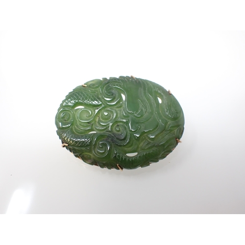 240 - A carved greenstone Brooch depicting a dragon in 9ct gold frame, approx 45mm wide, approx 13.30gms a... 