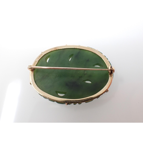 240 - A carved greenstone Brooch depicting a dragon in 9ct gold frame, approx 45mm wide, approx 13.30gms a... 