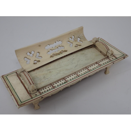 277 - A carved bone Cribbage Board with pierced domed cover containing dominoes and dice, possibly prisone... 