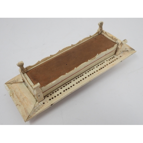 277 - A carved bone Cribbage Board with pierced domed cover containing dominoes and dice, possibly prisone... 