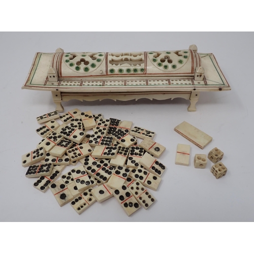 277 - A carved bone Cribbage Board with pierced domed cover containing dominoes and dice, possibly prisone... 