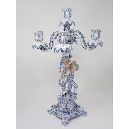 332 - A pair of Dresden blue and white Table Candelabra with floral encrusted arms and leafage sconces sup... 