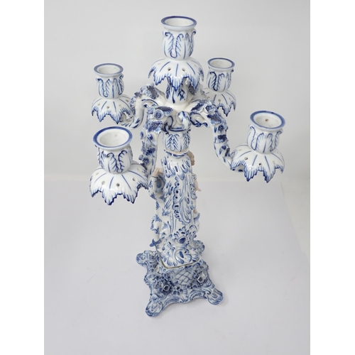 332 - A pair of Dresden blue and white Table Candelabra with floral encrusted arms and leafage sconces sup... 