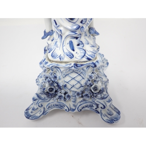 332 - A pair of Dresden blue and white Table Candelabra with floral encrusted arms and leafage sconces sup... 