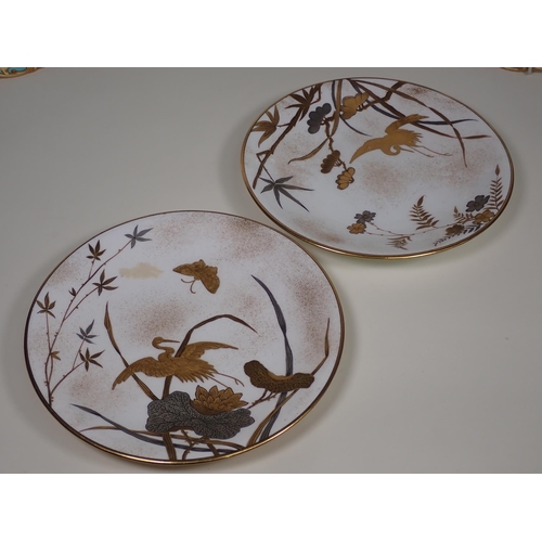 343 - A pair of Royal Worcester Plates with gilt storks, butterflies and water lillies, made for Mortlock'... 