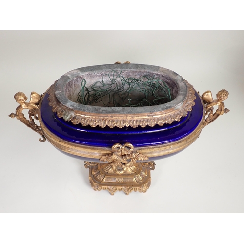 390 - A blue porcelain and gilt metal Jardiniere, possibly French, with winged cherub handles to the oval ... 