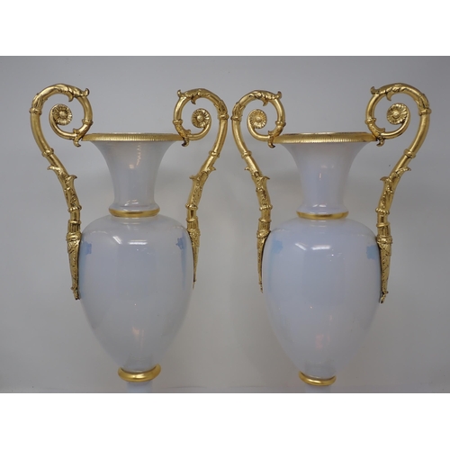 405 - An impressive pair of opaline glass baluster Vases on square plinth, having gilded ormolu mounts to ... 