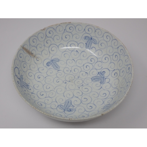 411 - An 18th Century blue and white Chinese Bowl decorated in a leaf and scroll pattern, 8in W, A/F