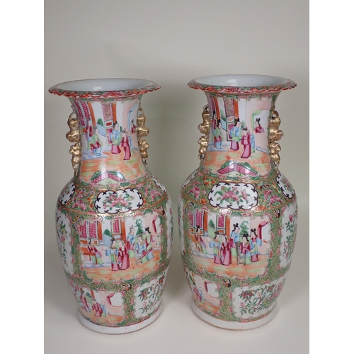 412 - A pair of Cantonese baluster Vases with moulded gilt handles, panels of interior scenes of figures i... 