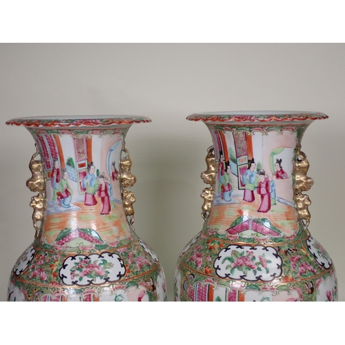 412 - A pair of Cantonese baluster Vases with moulded gilt handles, panels of interior scenes of figures i... 