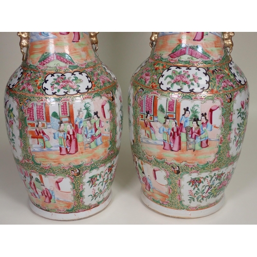 412 - A pair of Cantonese baluster Vases with moulded gilt handles, panels of interior scenes of figures i... 