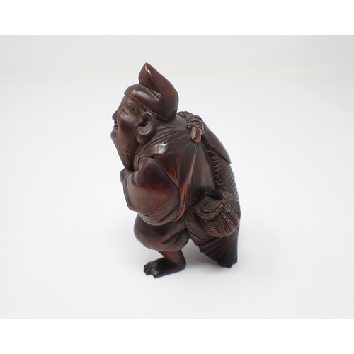 422 - A Japanese carved wooden Fisherman carrying large fish, 3 1/4in high