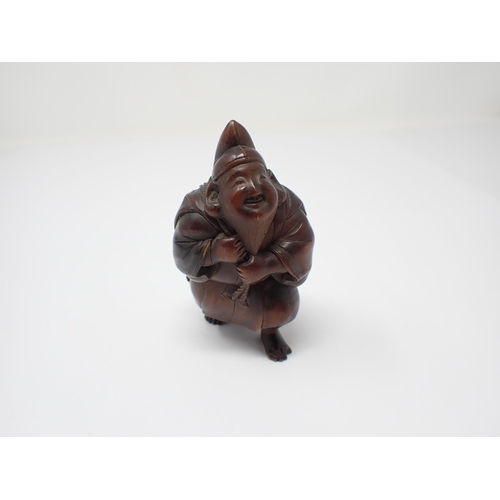 422 - A Japanese carved wooden Fisherman carrying large fish, 3 1/4in high