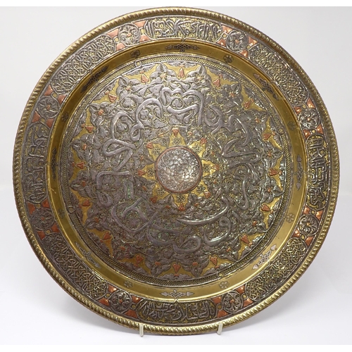 442 - An early 20th Century Syrian brass Charger inlaid script in silver and copper, 13 1/2in diameter