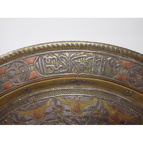 442 - An early 20th Century Syrian brass Charger inlaid script in silver and copper, 13 1/2in diameter