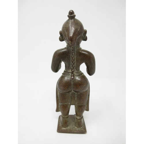 444 - An Indian/Tibetan bronze standing woman with plaited hair and outstretched arms, 6in