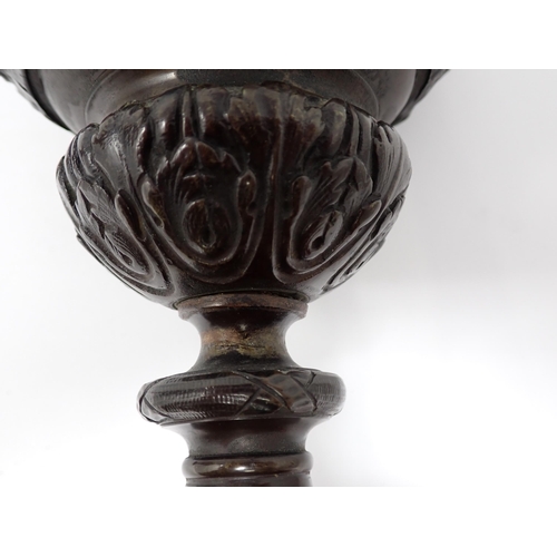 453 - A pair of bronze pedestal Ewers in the classical style, with cherub heads to the scroll handles and ... 