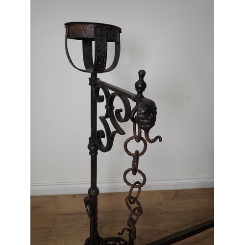 456 - An antique wrought iron central Fire Hearth Crane in the  16th Century style with pair of upright ca... 