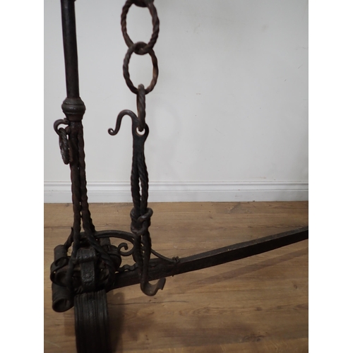 456 - An antique wrought iron central Fire Hearth Crane in the  16th Century style with pair of upright ca... 