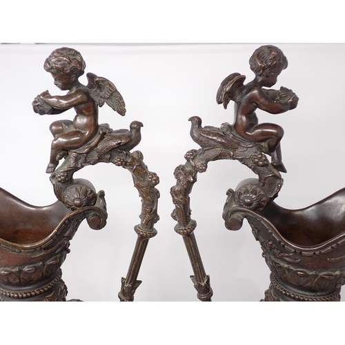 459 - A pair of 19th Century bronze Ewers with handles terminated with Putti and the bodies each with a fr... 