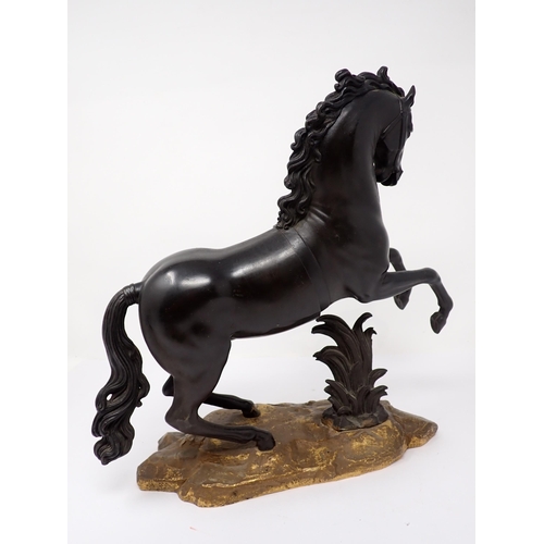 463 - A bronze Figure of a rearing horse on a rustic rocky base 12in H