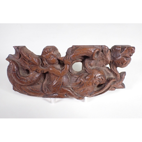 498 - A 19th Century pine Panel carved leaves and berries 1ft 9in x 6in, an oak Carving of cherub astride ... 